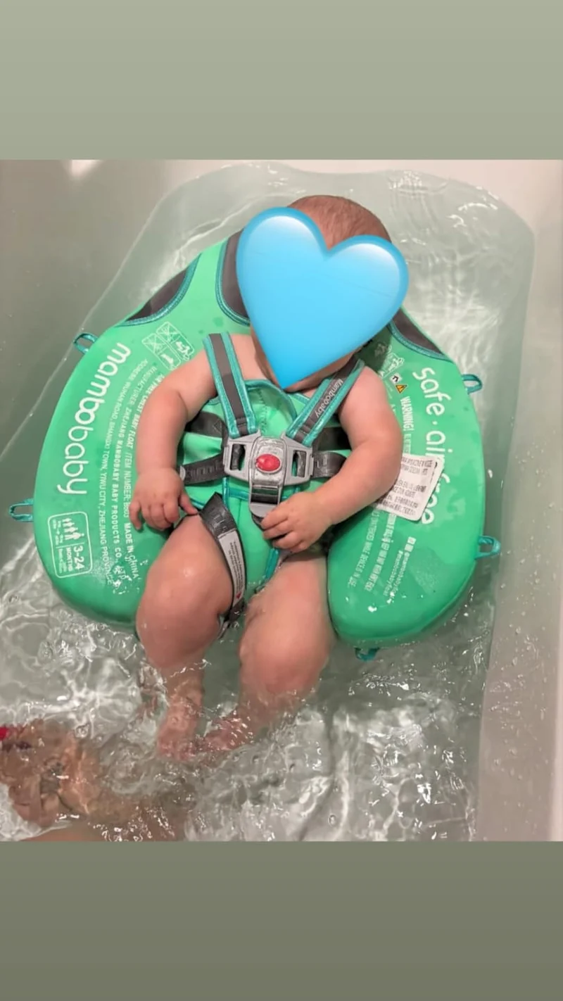 Baby resting comfortably in the mint FloatNest™ baby float with a parent close by